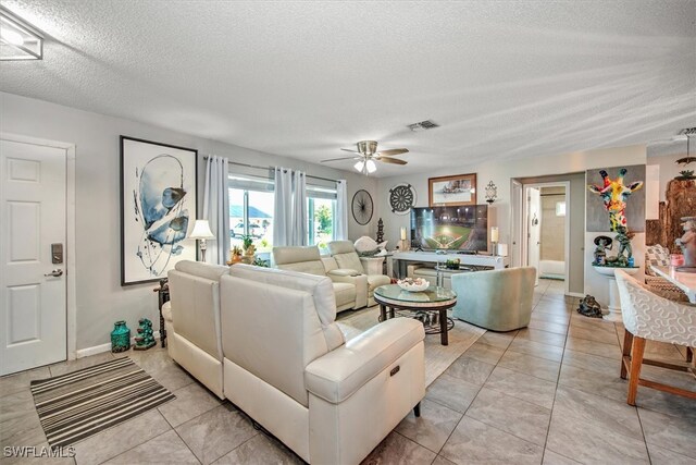 tiled living room featuring a textured ceiling and ceiling fan