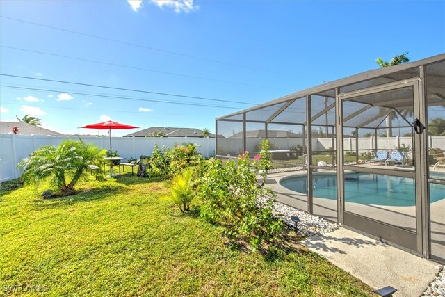 view of pool featuring a lawn and a lanai