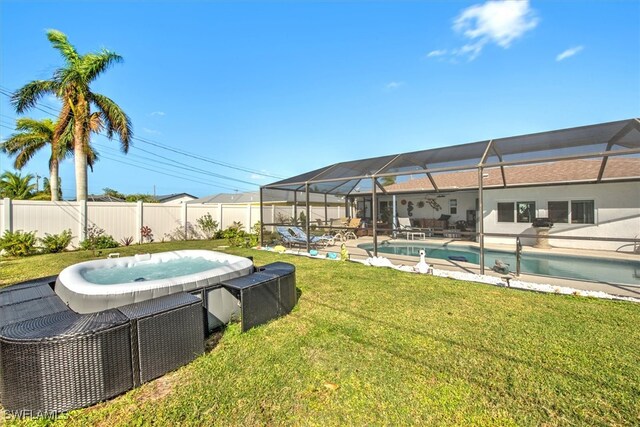 view of swimming pool with a lanai, a yard, and a jacuzzi