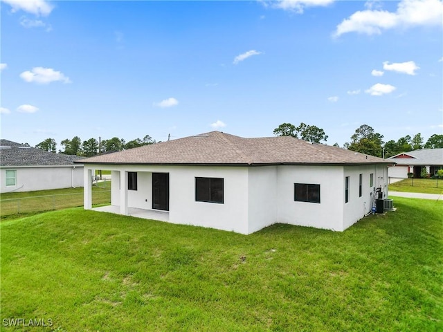 1902 Christopher Ave N, Lehigh Acres, FL 33971 - rear view of property with a yard, stucco siding, and a shingled roof