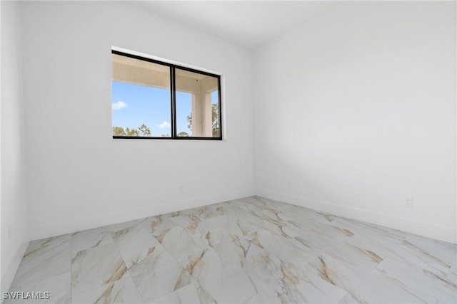 1902 Christopher Ave N, Lehigh Acres, FL 33971 - spare room featuring marble look tile flooring and baseboards