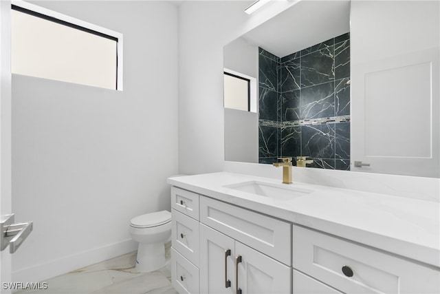 bathroom featuring vanity, toilet, and tiled shower