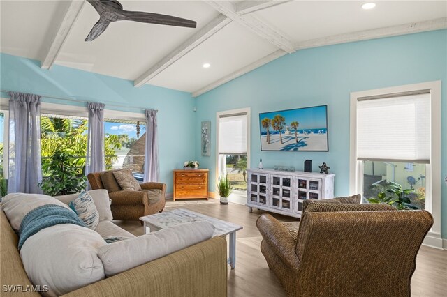 living room featuring vaulted ceiling with beams, ceiling fan, a healthy amount of sunlight, and light hardwood / wood-style floors