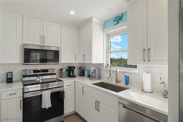 kitchen with white cabinets, sink, and appliances with stainless steel finishes