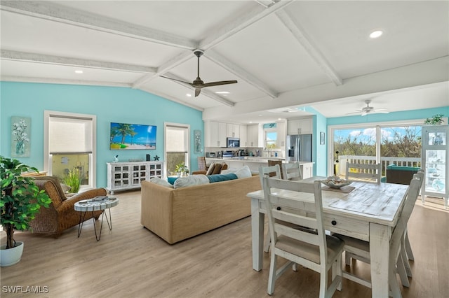 interior space with lofted ceiling with beams, plenty of natural light, and light hardwood / wood-style floors