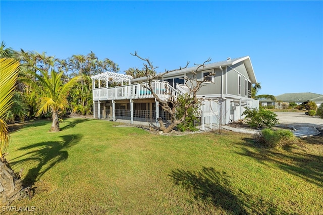 rear view of house with a lawn and a deck