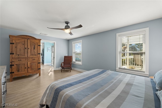 bedroom featuring multiple windows, ceiling fan, and light hardwood / wood-style floors