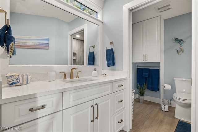 bathroom featuring hardwood / wood-style floors, vanity, and toilet