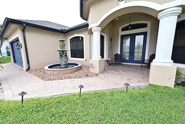 rear view of house featuring french doors, a garage, and a lawn