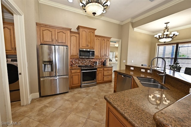 kitchen featuring sink, stainless steel appliances, pendant lighting, a notable chandelier, and ornamental molding