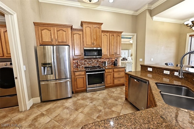 kitchen with backsplash, dark stone countertops, sink, crown molding, and appliances with stainless steel finishes