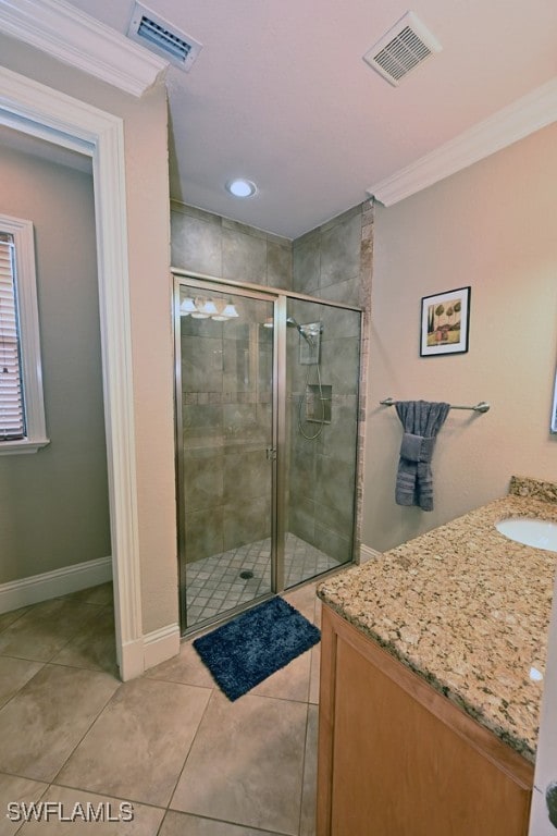 bathroom with vanity, crown molding, a shower with shower door, and tile patterned floors