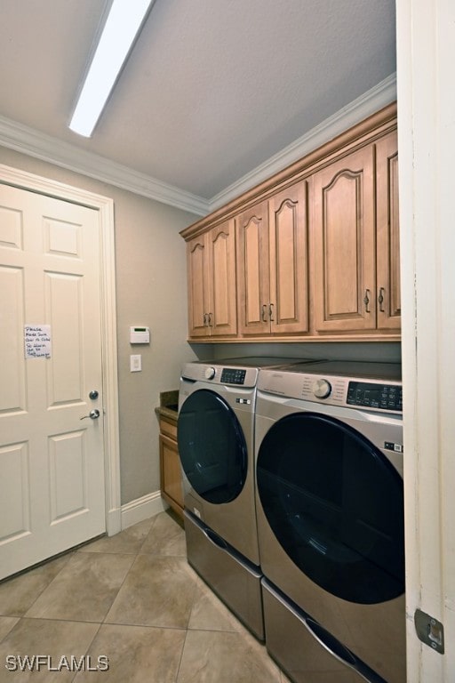 clothes washing area featuring light tile patterned floors, ornamental molding, cabinets, and separate washer and dryer