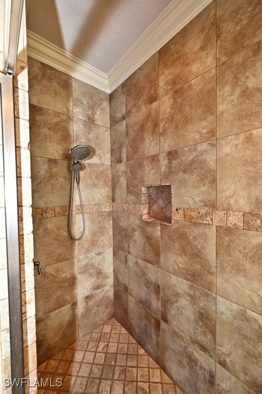 interior details with a tile shower and crown molding