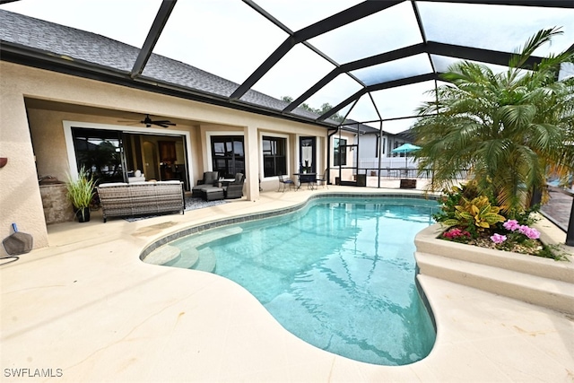 view of pool with a patio area, glass enclosure, and ceiling fan