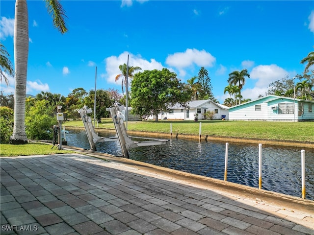 view of dock with a yard and a water view