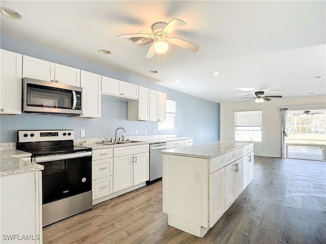 kitchen featuring sink, white cabinetry, light wood-type flooring, appliances with stainless steel finishes, and ceiling fan