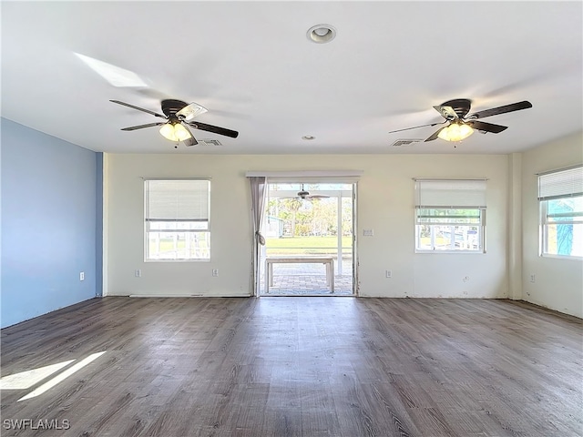 unfurnished room featuring ceiling fan, a healthy amount of sunlight, and wood-type flooring