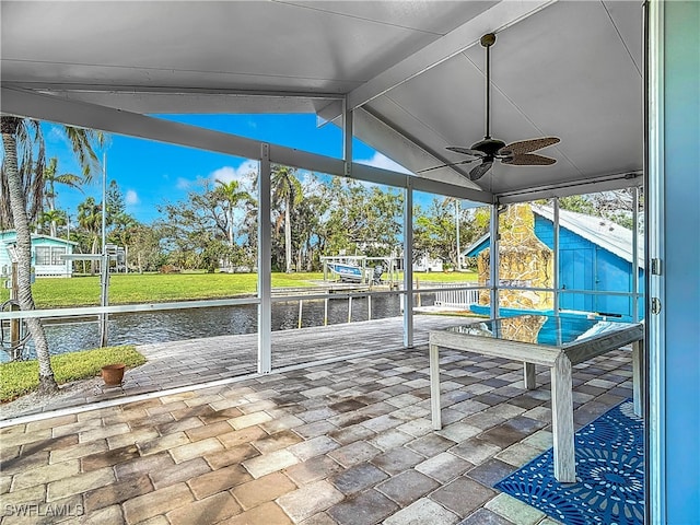 unfurnished sunroom featuring lofted ceiling with beams, a water view, and ceiling fan