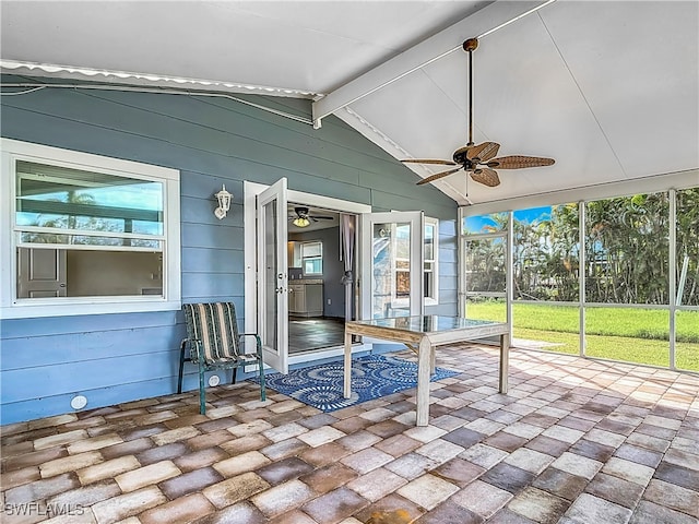 unfurnished sunroom featuring vaulted ceiling with beams