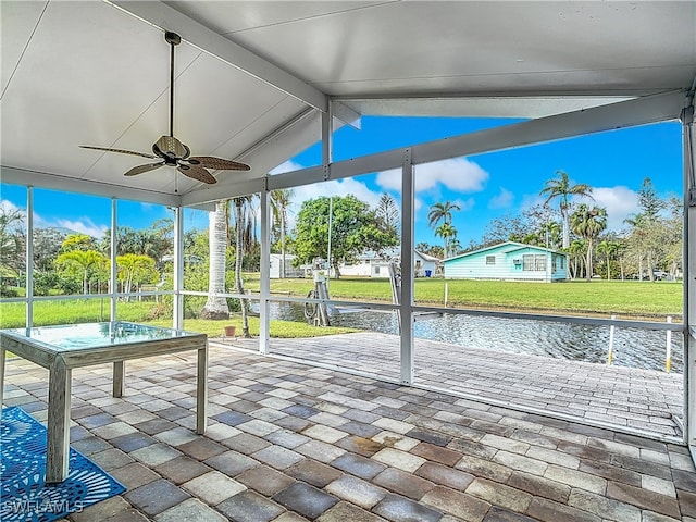 unfurnished sunroom featuring a water view, ceiling fan, and lofted ceiling