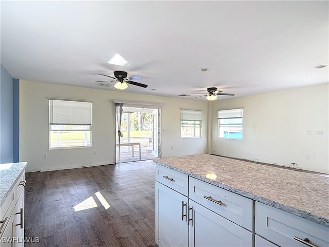 kitchen featuring white cabinetry, light stone countertops, ceiling fan, and dark hardwood / wood-style flooring