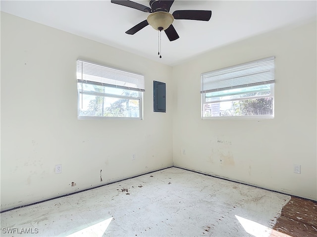 spare room featuring a healthy amount of sunlight, electric panel, and ceiling fan