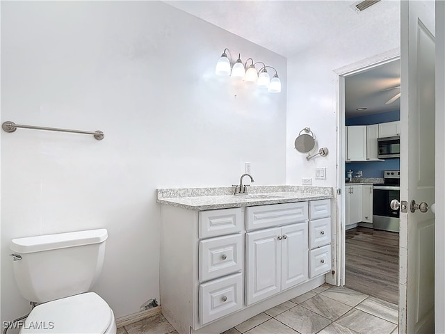 bathroom featuring vanity, hardwood / wood-style flooring, and toilet