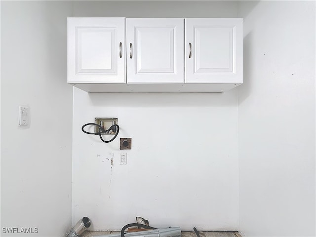 clothes washing area featuring cabinets, hookup for an electric dryer, and hookup for a washing machine