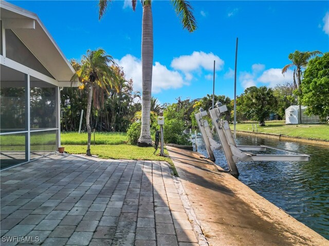 view of patio with a water view and a dock