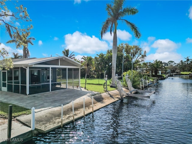 exterior space featuring a boat dock, a water view, and a sunroom