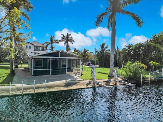 rear view of house with a patio, a yard, a water view, and a sunroom