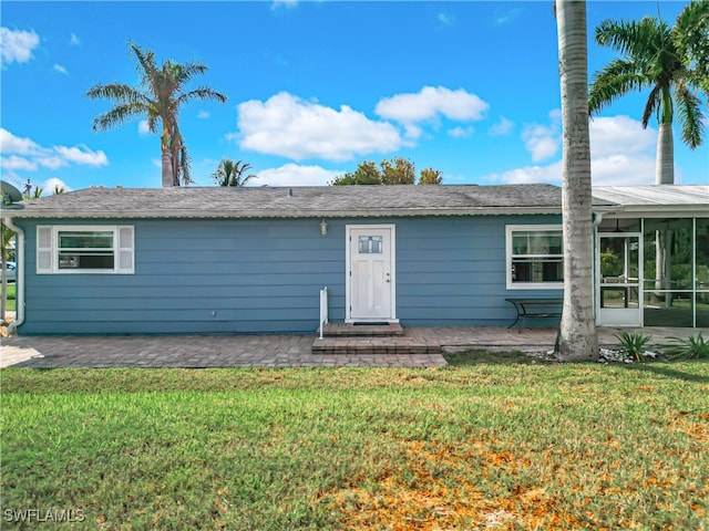 view of front of home featuring a sunroom and a front lawn