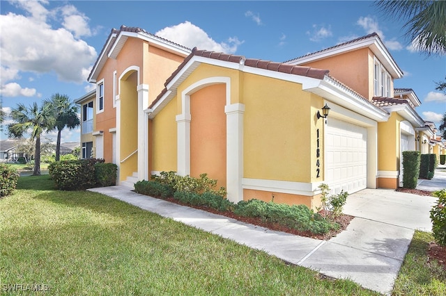 11842 Bayport Ln Unit 2104, Fort Myers, FL 33908 - view of property exterior with a garage, a yard, concrete driveway, stucco siding, and a tile roof