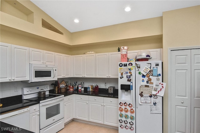 kitchen with white cabinets, white appliances, light tile patterned floors, and lofted ceiling