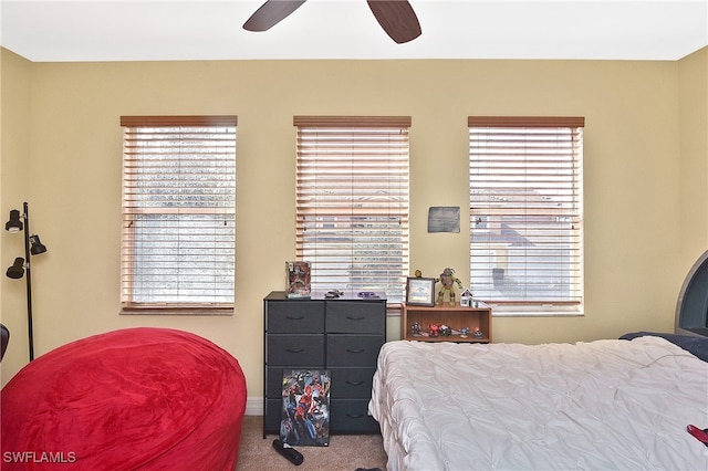 bedroom featuring carpet, multiple windows, and ceiling fan