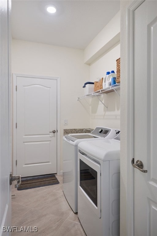 laundry room featuring light tile patterned floors and washer and clothes dryer