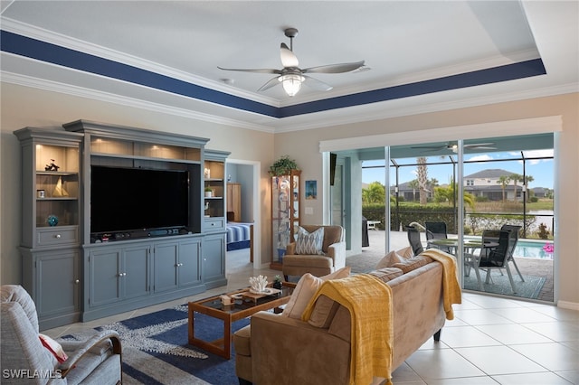 living room with crown molding, ceiling fan, a raised ceiling, and light tile patterned flooring