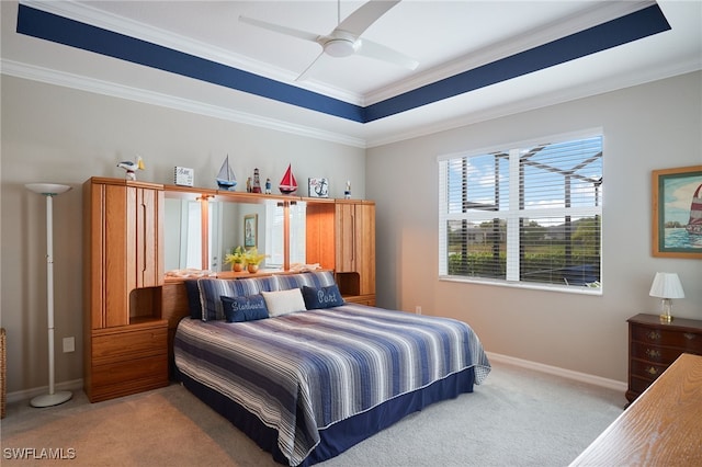 bedroom with light colored carpet, ceiling fan, crown molding, and a tray ceiling