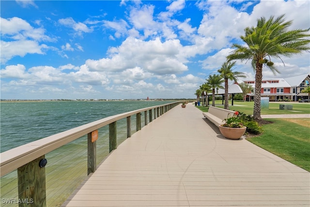 view of dock featuring a water view and a yard