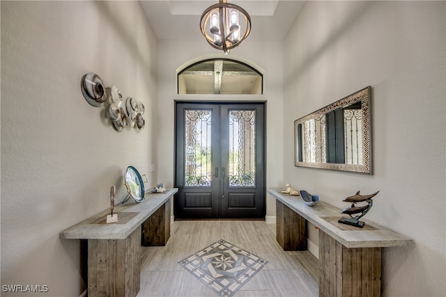 entrance foyer featuring french doors and an inviting chandelier