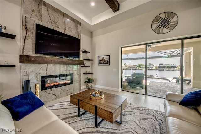 living room featuring light wood-type flooring, beamed ceiling, and a tile fireplace