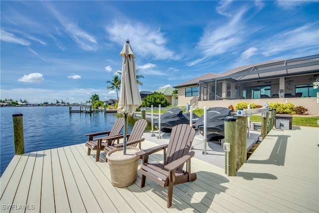 view of dock with a lanai and a water view