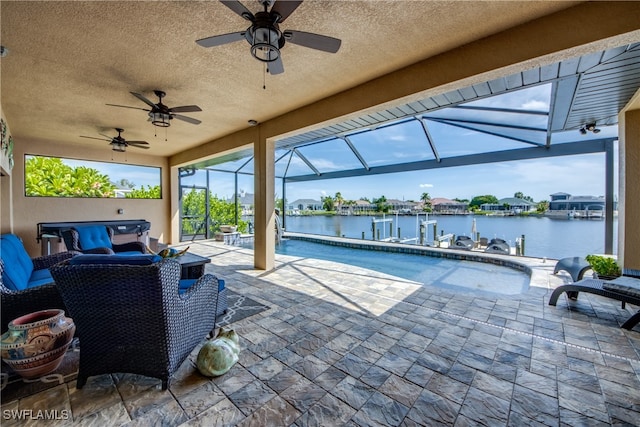 view of pool featuring a water view, ceiling fan, glass enclosure, and a patio area