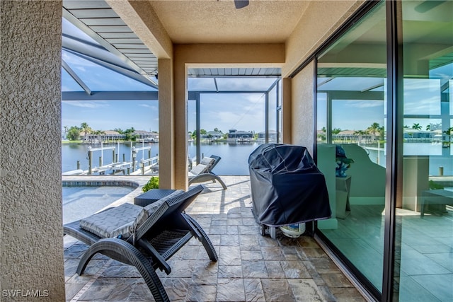 sunroom featuring a water view