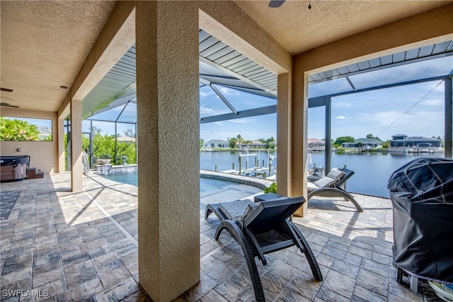 view of patio / terrace featuring a grill, a water view, glass enclosure, and ceiling fan