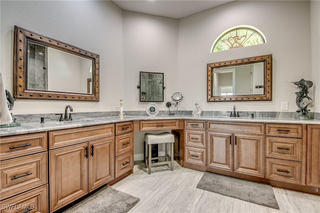 bathroom featuring vanity, hardwood / wood-style flooring, and a towering ceiling