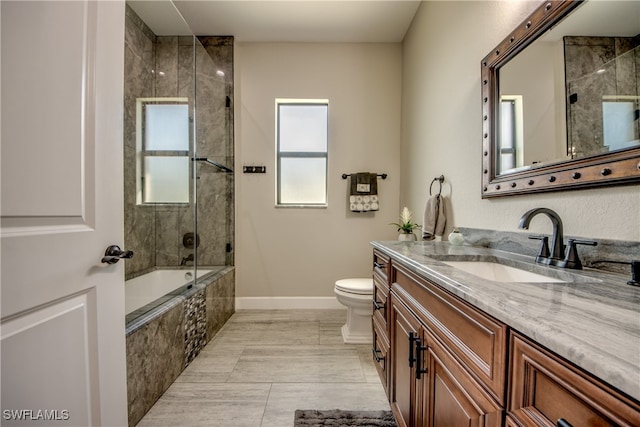 full bathroom featuring toilet, tiled shower / bath, vanity, and tile patterned flooring