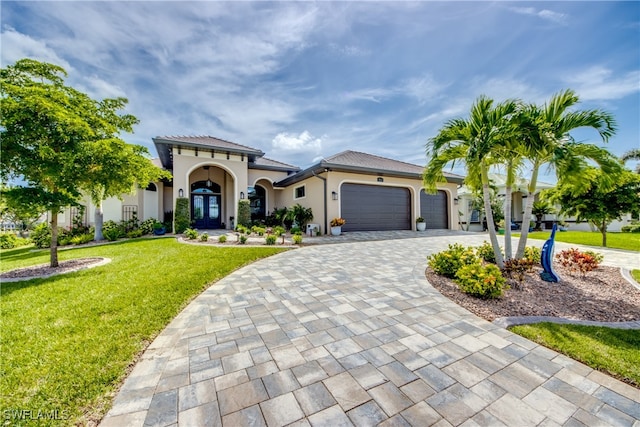 mediterranean / spanish home with a front lawn and a garage