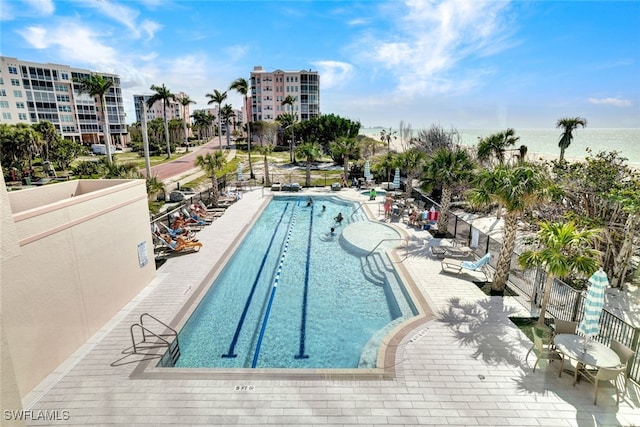 view of pool featuring a patio and a water view